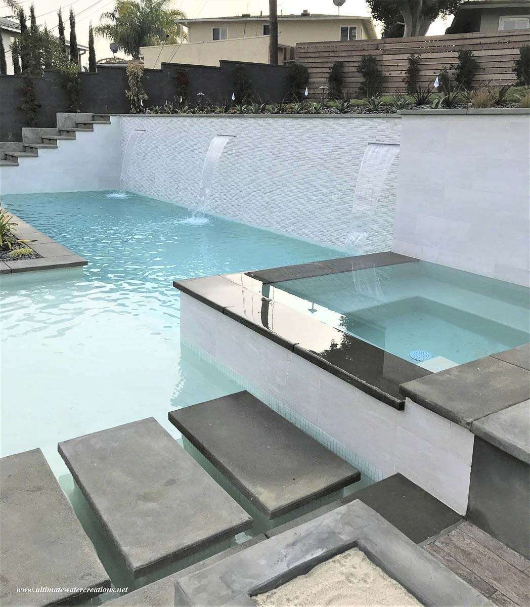 Modern acrylic-wall pool at dusk in front of a contemporary Los Angeles estate